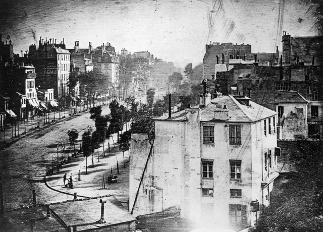 A primeira fotografia em que um ser humano apareceu foi em um instantâneo capturado por Louis Daguerre. A exposição durou cerca de sete minutos e teve como objetivo capturar a Boulevard du Temple, uma rua em Paris, na França. No canto inferior esquerdo da fotografia, podemos ver um homem de pé tendo seu sapado polido. Ele ficou lá parado tempo suficiente para sair na foto de longa exposição.