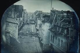 A revolta da França. Esta foto mostra barricadas criadas às pressas em torno da rue Saint-Maur, em Paris, em 25 de junho de 1848, durante o que às vezes é chamado de insurreição dos Dias de Junho. Durante esta breve revolta, que durou alguns dias, os trabalhadores se revoltaram contra os planos do governo francês de restringir um projeto de obras públicas, uma medida que eliminaria seus empregos. Milhares de pessoas foram mortas na revolta.